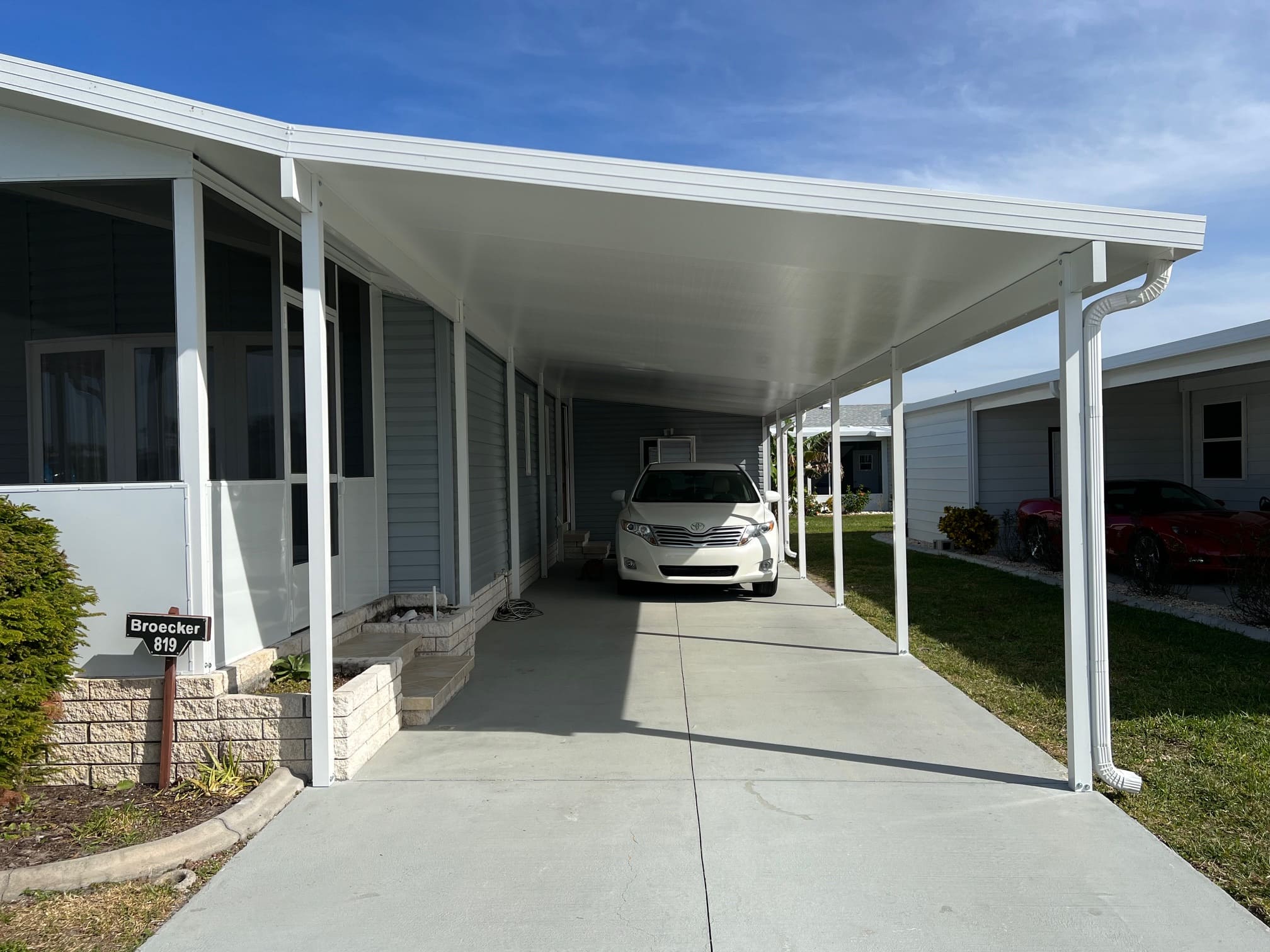 Modern louvered hurricane shutters on Florida patio pergola, exterior storm protection with poolside seating